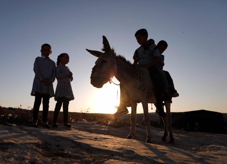 Niños palestinos van en burro al colegio en la Franja de Gaza. FOTO: EFE