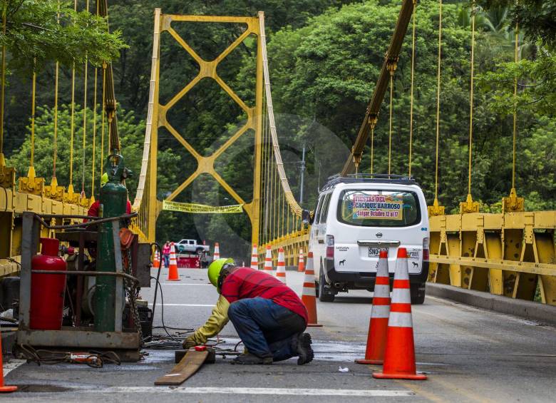 Con placas y cables de acero estos técnicos iniciaron la reparación y reforzamiento del puente de Bolombo. FOTO Jaime Pérez