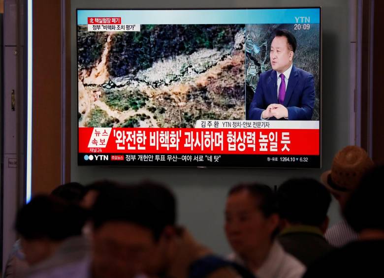 Personas observan los reportes de la prensa sobre el desmantelamiento del centro de pruebas nucleares. FOTO REUTERS
