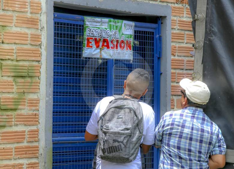 Funcionarios de la Dian, acompañados de la Policía Nacional realizan el cierre de los establecimientos. FOTO Juan Antonio Sánchez