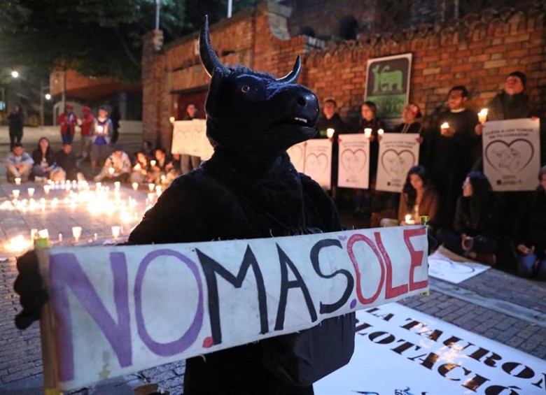 Decenas de personas sostienen velas este sábado durante una jornada de protesta contra las corridas de toros, en la Plaza de Toros La Santamaría de Bogotá. EFE