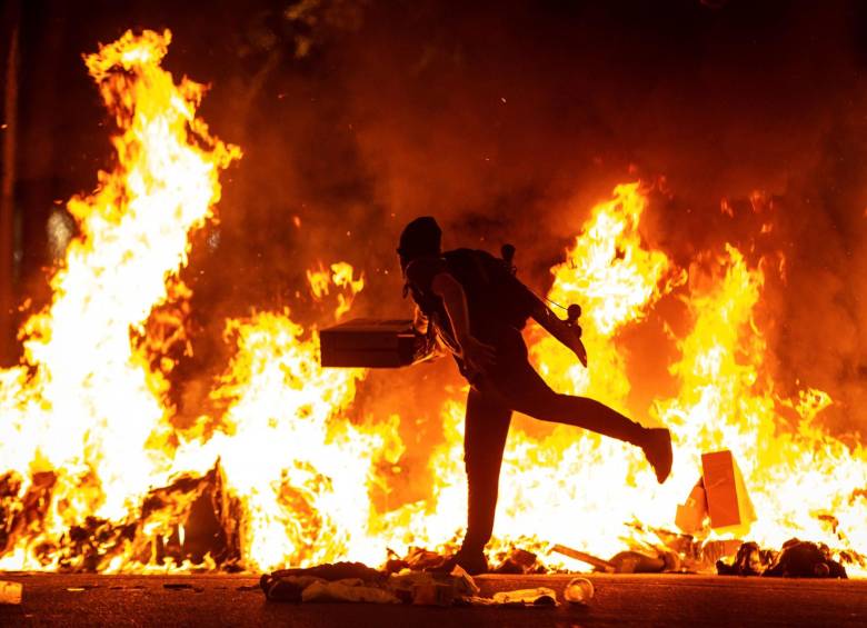 Un manifestante echa fuego a carteles tras la movilización de este martes. FOTO EFE