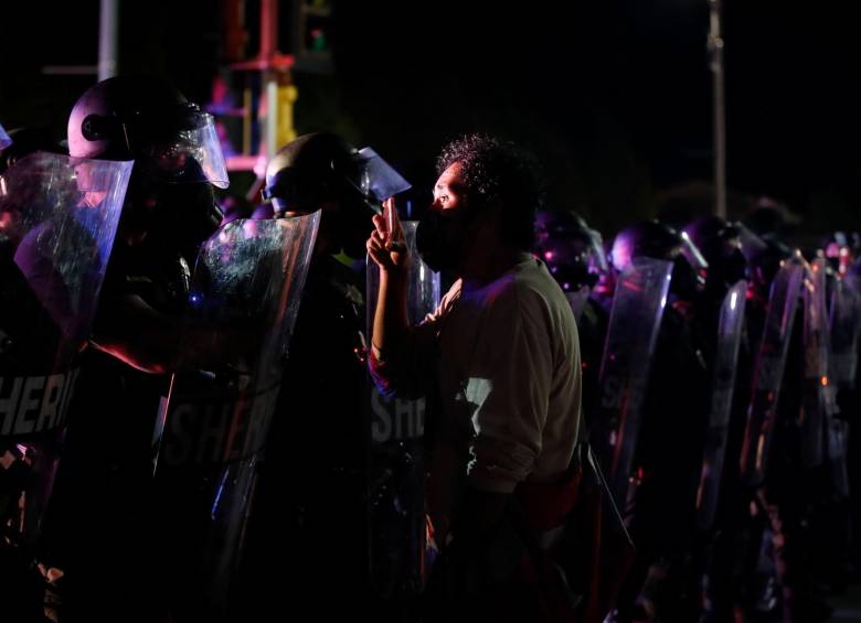 Un manifestante sostiene su teléfono celular mientras se enfrenta al alguacil fuera del Palacio de Justicia del Condado durante las manifestaciones contra el tiroteo de Jacob Blake en Kenosha, Wisconsin. FOTO AFP