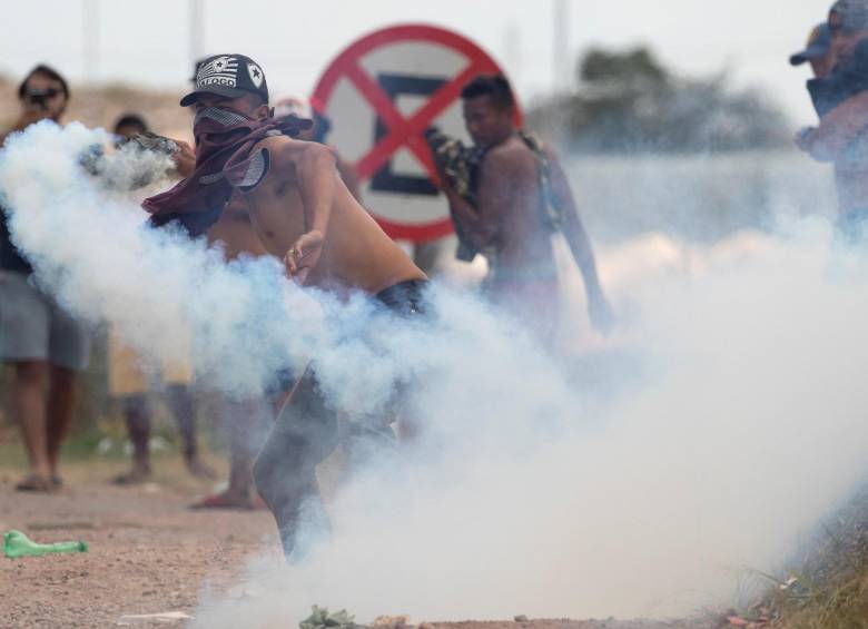  Venezolanos se enfrentan a los Policías de la Guardia Nacional este domingo en la frontera entre Pacaraima (Brasil) y Venezuela. FOTO: EFE