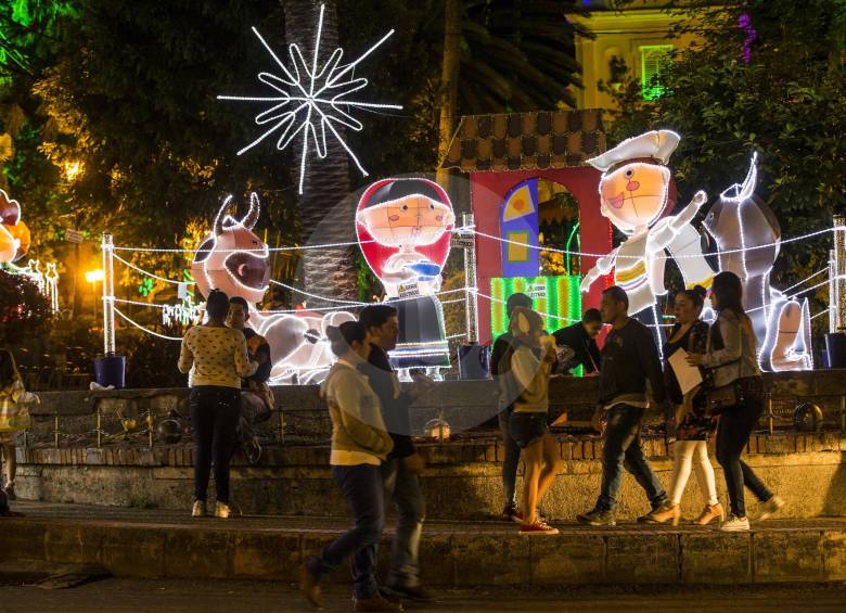 Las personas se aglomeran en torno al pesebre, que es el montaje principal del alumbrado