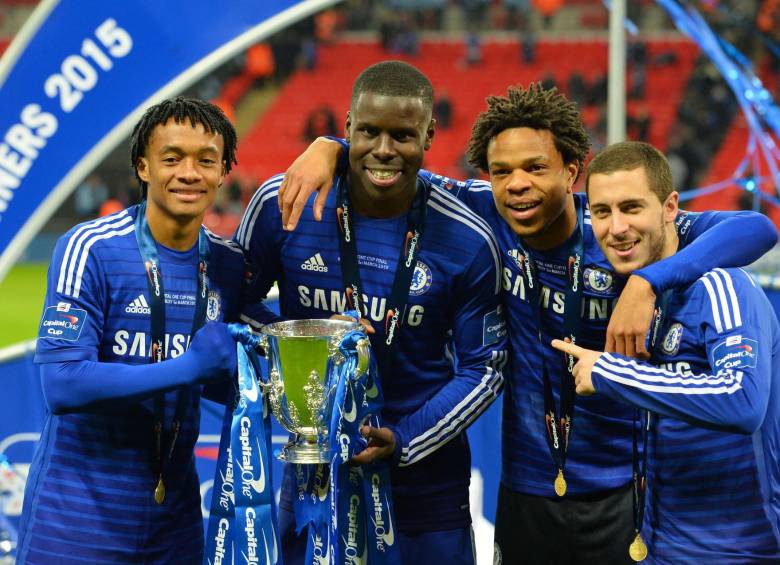 El colombiano Juan Guillermo Cuadrado agarra el trofeo de la Copa de la liga inglesa, junto a los franceses Kurt Zouma y Loic Remy; y el volante belga Eden Hazard. FOTO afp