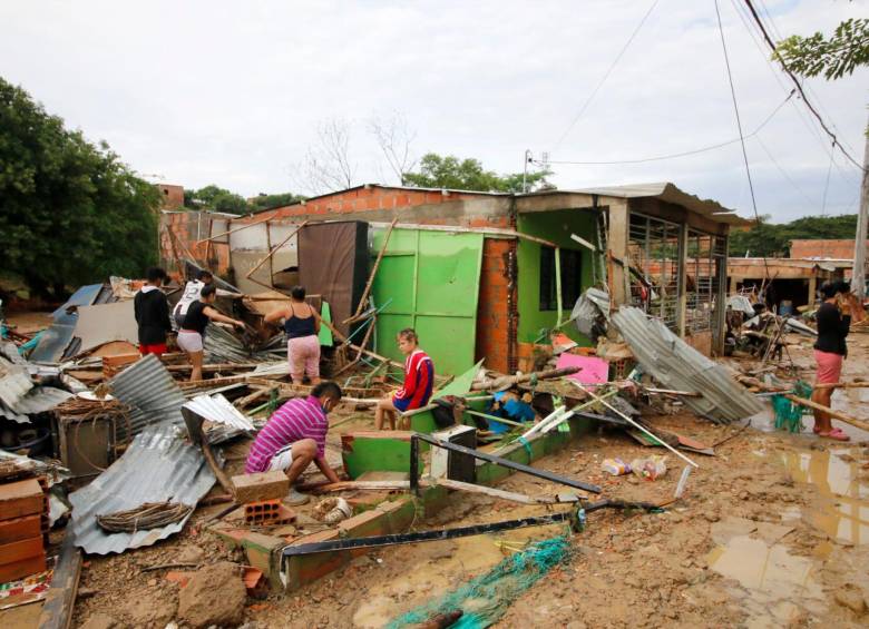 Personas rescatan sus pertenencias de los escombros tras las fuertes lluvias del pasado miércoles en Cúcuta, Norte de Santander. FOTO AFP