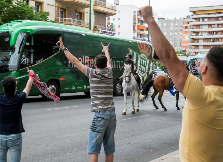 Guardando la distancia, los aficionados del Betis saludaron el paso del equipo hacia el estadio. Fotos efe