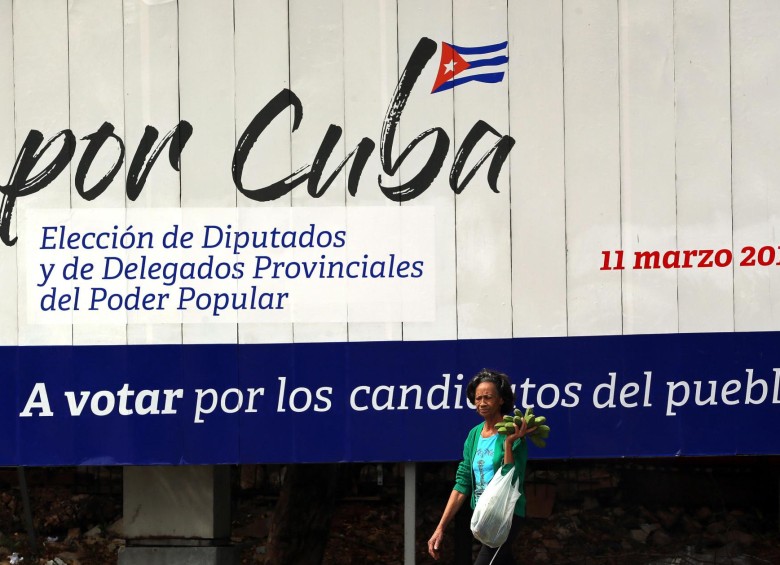Una mujer camina frente a un cartel alusivo a las elecciones generales, en La Habana (Cuba). FOTO EFE