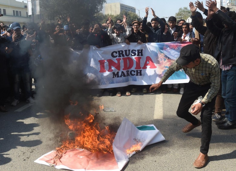  Paquistaníes queman un cartel del primer ministro indio, Narendra Modi, durante una protesta en Lahore, Pakistán. El Ejército paquistaní anunció este miércoles el derribo de dos cazas indios dentro de su espacio aéreo y la detención de dos de sus pilotos. Foto: EFE