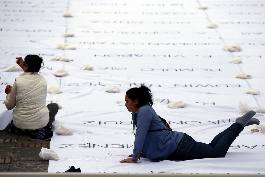En dos días escribieron con ceniza 1900 nombres de secuestrados, desaparecidos, falsos positivos, asesinados, víctimas, en 7000 metros de tela blanca. FOTO Colprensa