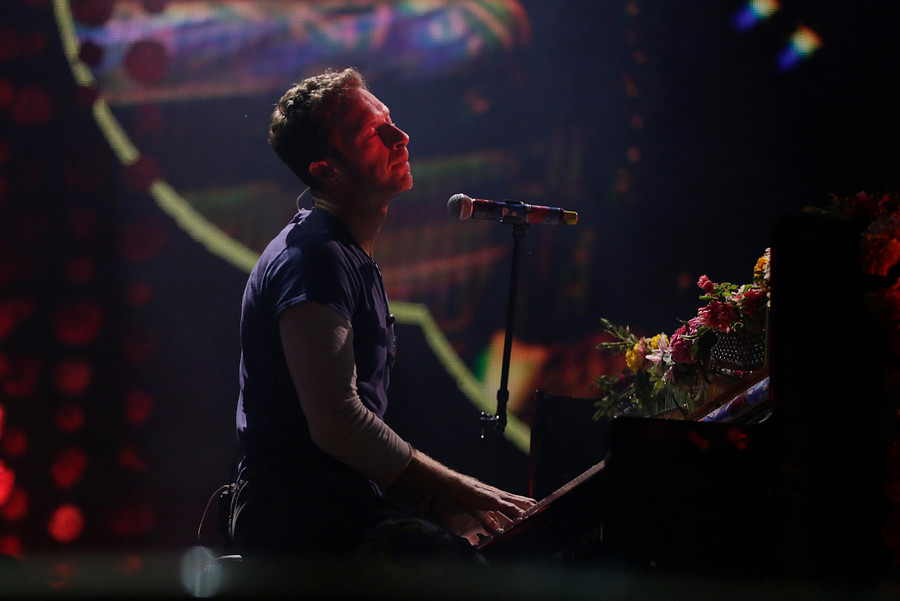 Por momentos Chris Martin se sentó en el piano. FOTO Colprensa