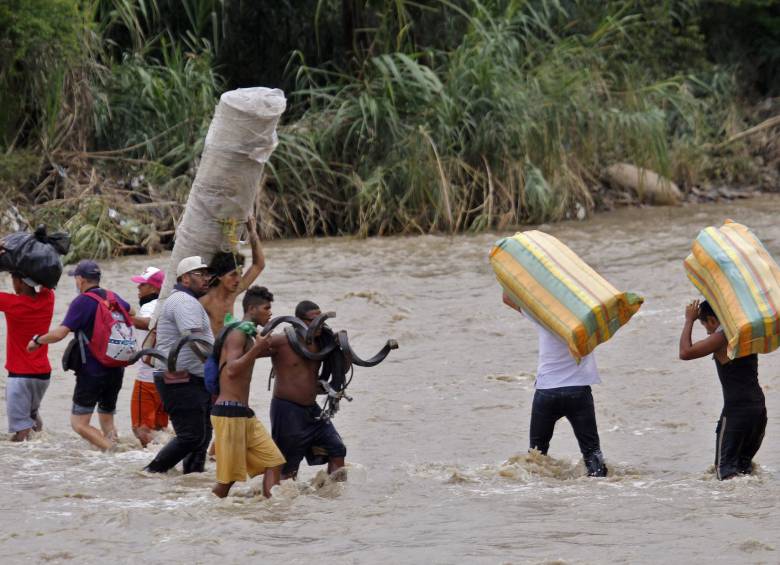 Migrantes venezolanos atraviesan el río Táchira para llegar a Colombia. FOTO AFP
