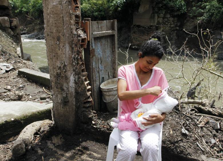 En las ruinas de su casa, destruida por la avalancha del pasado 11 de abril en Andes, Laidy T. Flórez, contempla a su pequeña hija. Las dos sobrevivieron al desastre. FOTO Donaldo Zuluaga