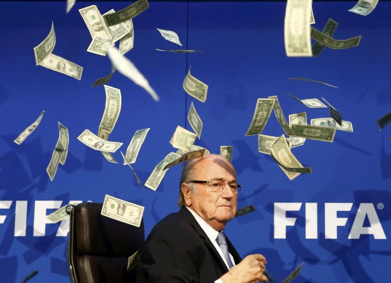 El humorista Lee Nelson se coló este lunes en la rueda de prensa del presidente de la Fifa, Joseph Blatter en Zúrich y le lanzó billetes de dólar. FOTO REUTERS
