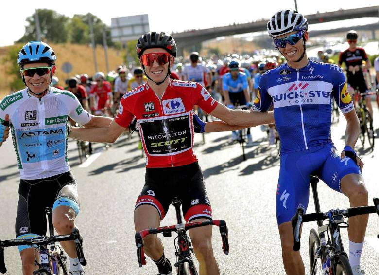 Al extremo izquierdo el colombiano Miguel Ángel López, tercero en el podio de la Vuelta a España; Simon Yates, el campeón y Enric Mas, subcampeón. Foto EFE