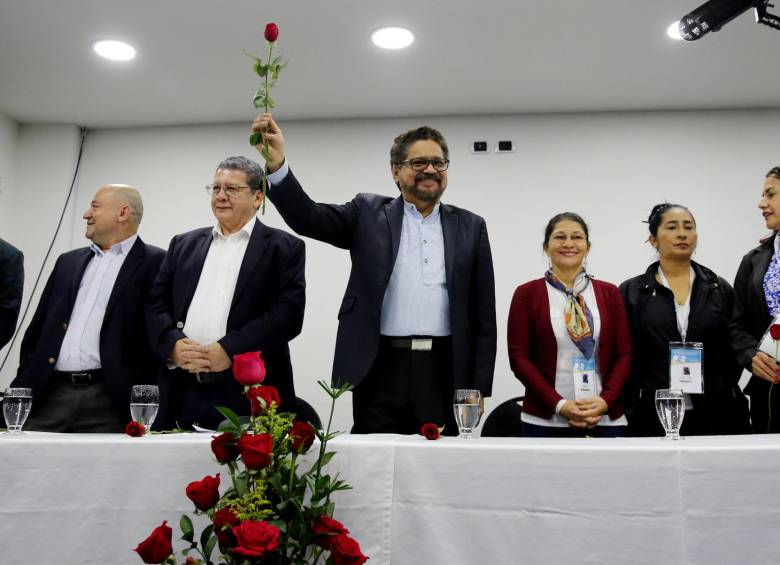 Iván Márquez, quien fue el jefe negociador de las Farc, levanta una rosa roja, que es, además, el símbolo del naciente partido político. En la mesa está acompañado por miembros del Secretariado y mujeres de la organización. FOTO EFE.