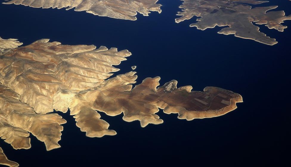 La ciudad de Susuz se ve en la orilla norte de la presa de Ataturk a través de la ventana de un avión. FOTO Reuters