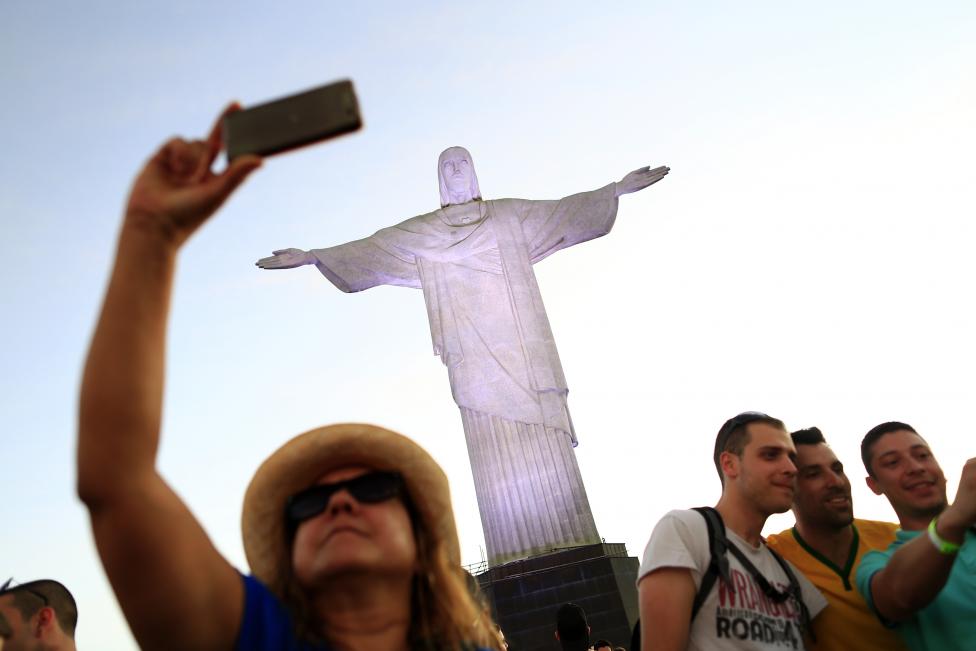 Una mujer posa frente a la estatua del Cristo Redentor antes de la Copa del Mundo de 2014 en Río de Janeiro. FOTO: Tony Gentil / REUTERS 
