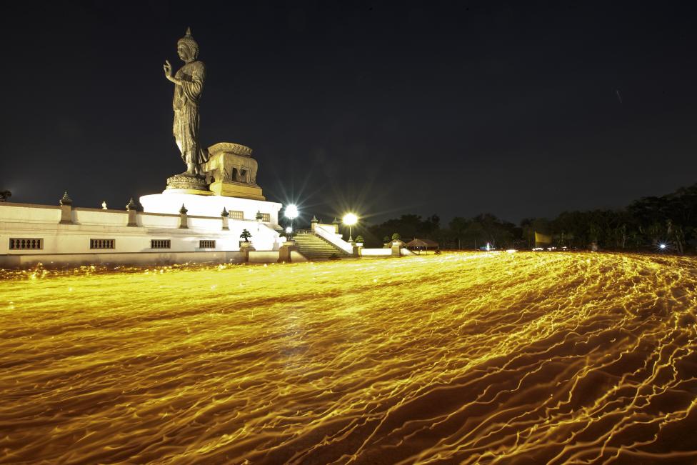 Los budistas sostienen velas alrededor de una gran estatua de Buda durante el día del Makha Bucha en un templo en la provincia de Nakhon Pathom a las afueras de Bangkok. FOTO Reuters