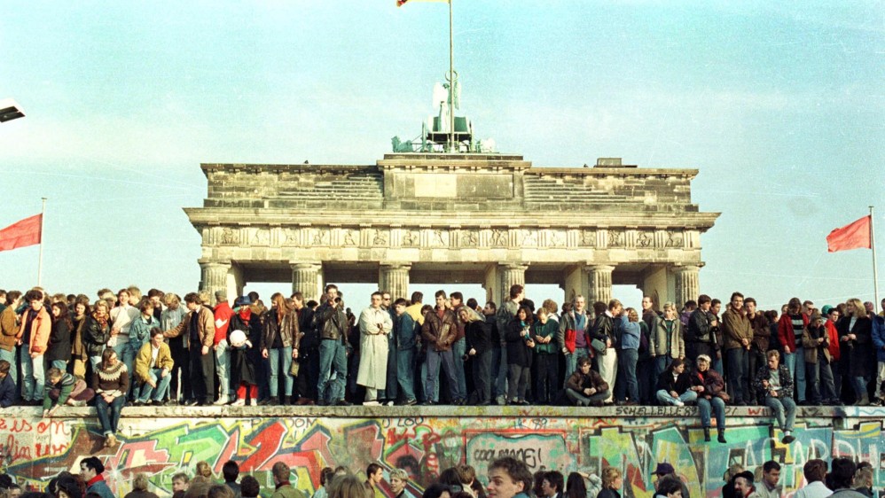 Ciudadanos de Berlín Occidental celebran el hecho histórico sobre el muro de Berlín, frente a la Puerta de Brandeburgo. Foto de archivo tomada el 11 de noviembre de 1989. FOTO REUTERS