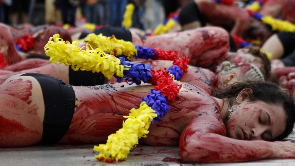 Aactivistas con sus cuerpos semidesnudos, “ensangrentados” y con banderillas realizaron un acto en Medellín para rechazar las corridas de toros y pedir una ley que prohíba estos “espectáculos de muerte” en Colombia. FOTO EFE 