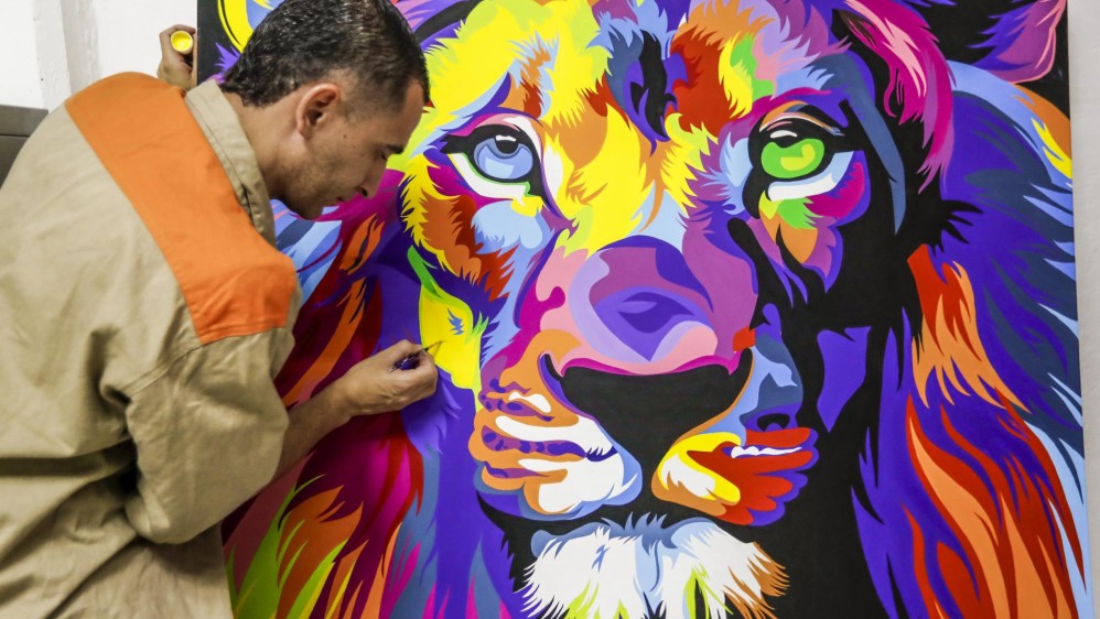 Faver, quien esta recluido en la cárcel La Paz, de Itagüi ( Antioquia), pinta un león con la técnica pop art. En esta estrategia participan por lo menos 40 internos. Foto : Jaime Pérez