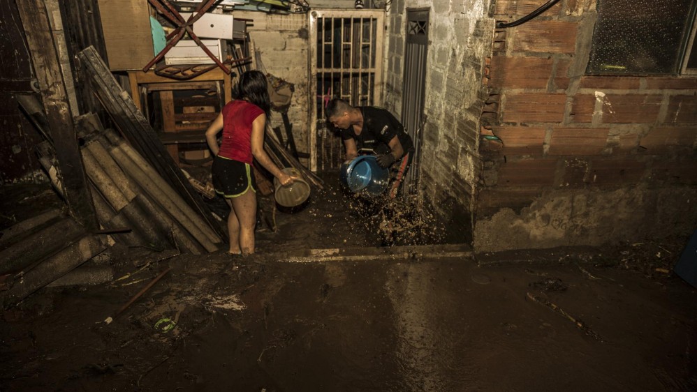 Aún con la lluvia encima, las personas no se detenían en su empeño de sacar el agua y pantano. FOTO CAMILO SUÁREZ