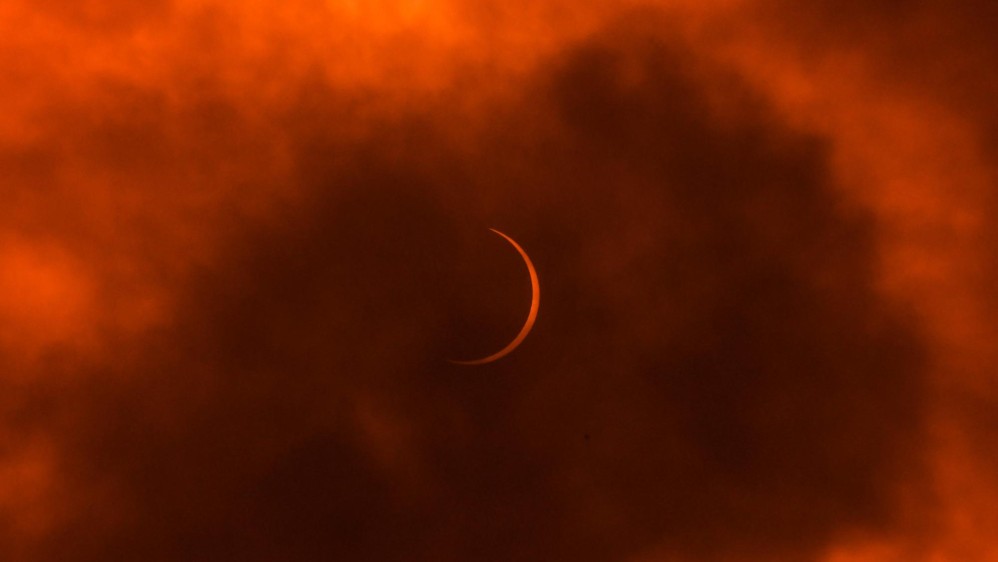 La luna se mueve frente al sol durante un eclipse solar anular visto a través de las nubes desde Nueva Delhi el 21 de junio de 2020. FOTO AFP