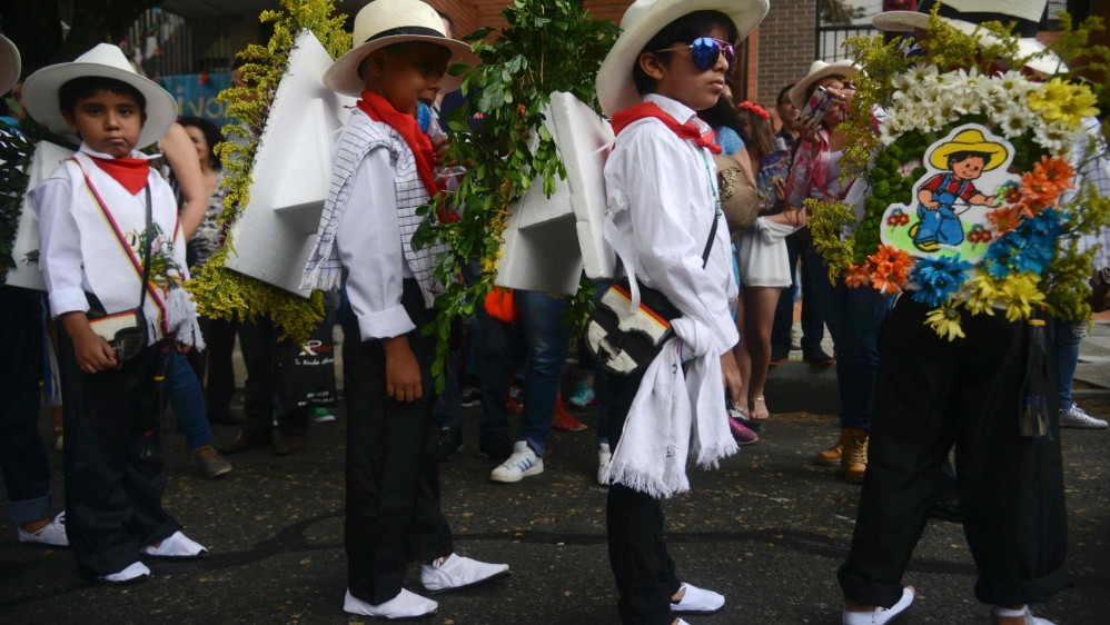 Niños de entre 4 y 11 años de edad exhibieron pequeños arreglos florales que cargaron en sus espaldas con mensajes alusivos a la conservación del medio ambiente, los valores y el fútbol. FOTO AFP