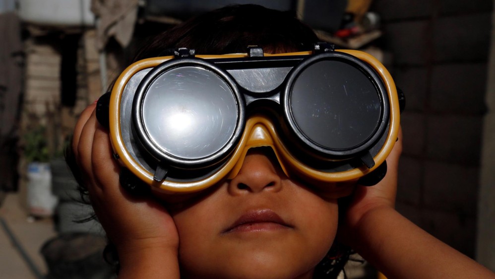 Un niño usa anteojos protectores especiales para observar un eclipse solar parcial en Sanaa, Yemen, 21 de junio de 2020. FOTO EFE